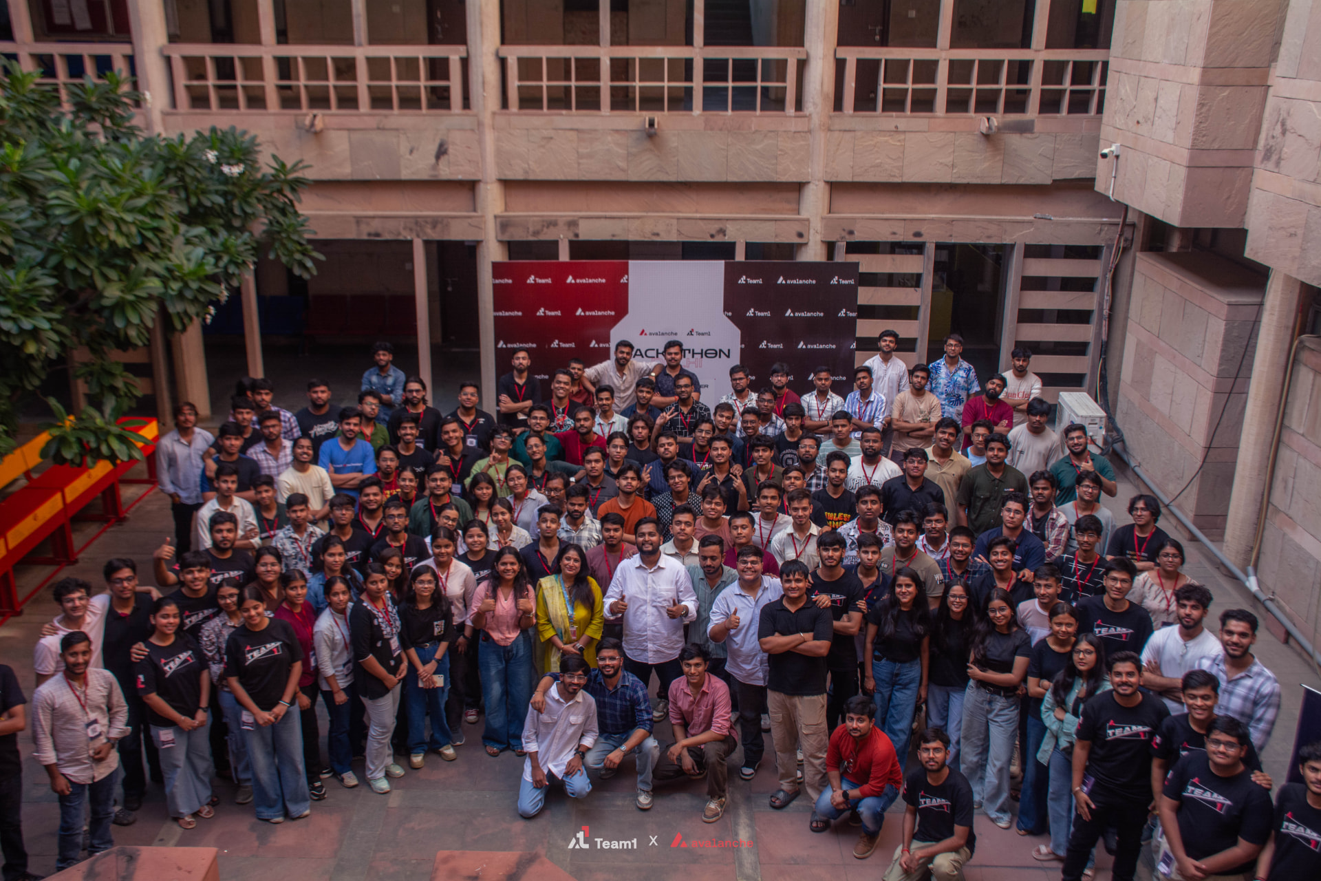 Hackathon participants assembled in a university courtyard for a group photograph