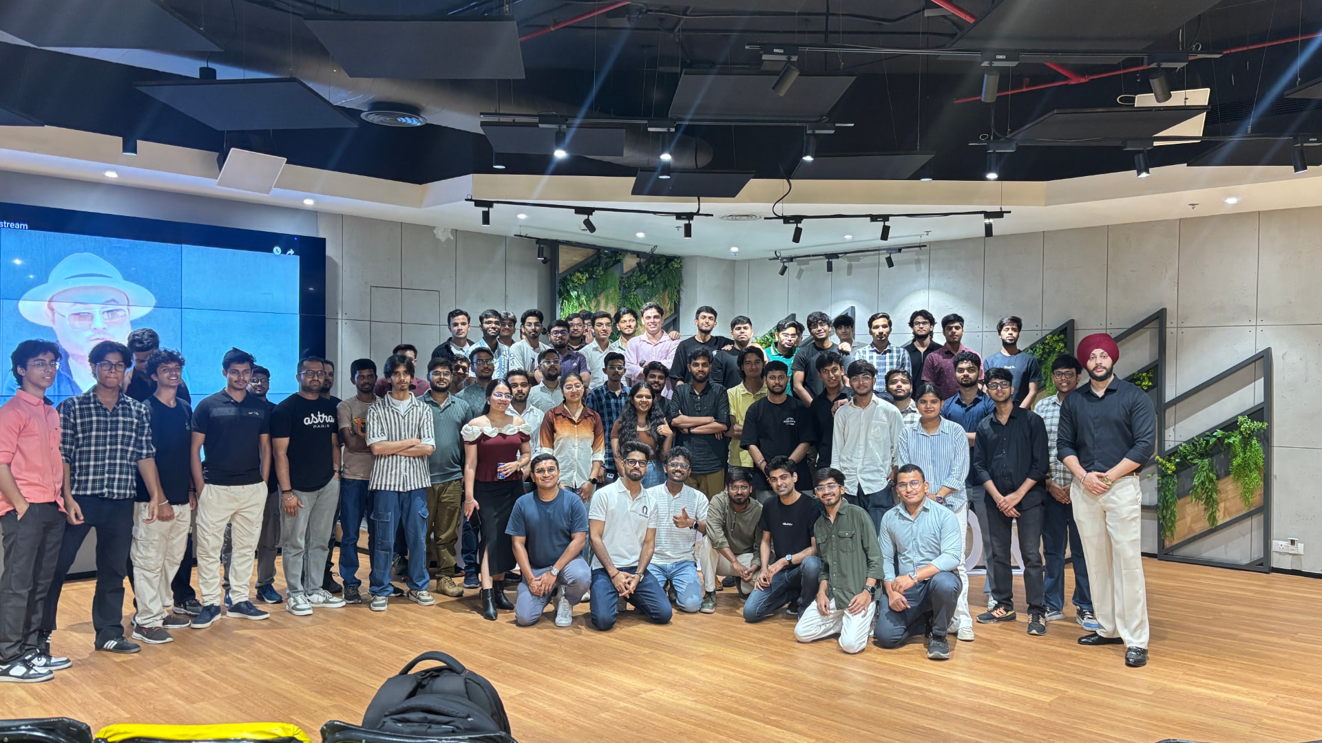 Community members gathered indoors at a partner program for a group photograph